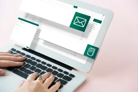 A marketer designing an email newsletter template on a laptop screen at a desk