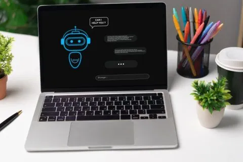 Laptop displaying an AI chatbot interface on a desk, illustrating the Google AI Essentials course on Coursera and beginner-friendly AI training.
