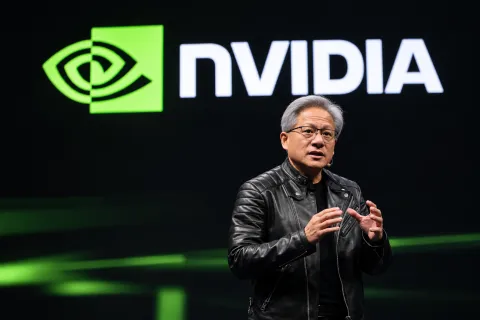Jensen Huang speaking onstage with an NVIDIA backdrop